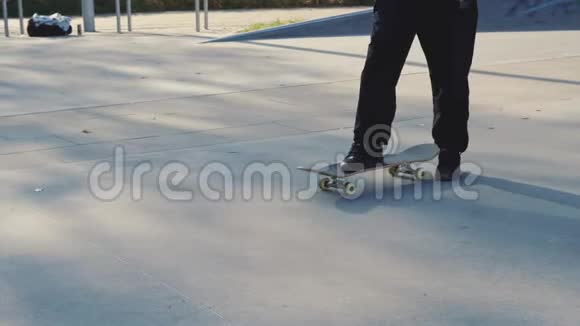 秋日混凝土滑板公园滑板运动员腿特写视频的预览图