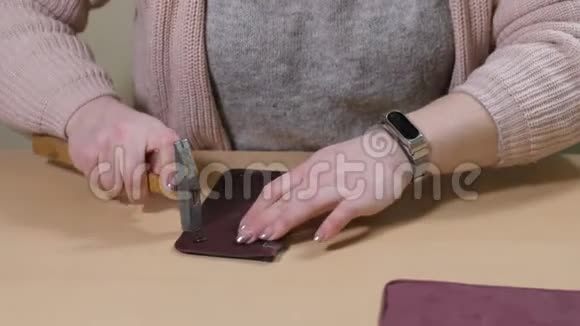 女性手在皮夹零件上涂胶视频的预览图