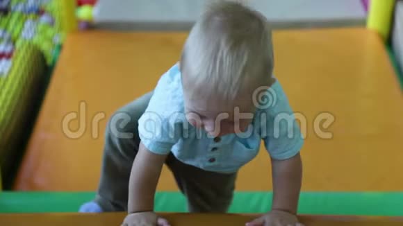 小男孩在儿童娱乐中心爬墙障碍物慢动作视频的预览图