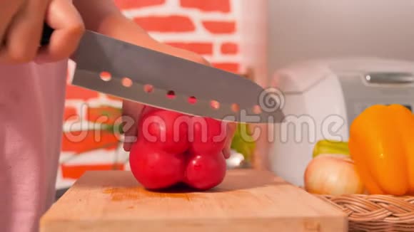厨房砧板上用刀子切下的红铃椒视频的预览图