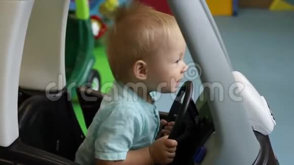 慢动作玩具车中的儿童舵轮儿童的游戏中心男孩开玩具车视频的预览图