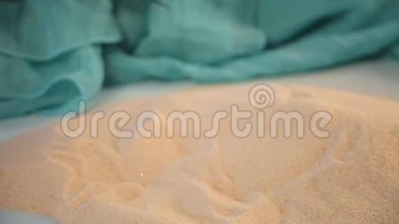 女人的手把红海星放在白沙上视频的预览图
