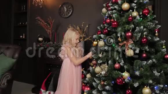 一个十岁的女孩靠近新年树手里拿着一个新年玩具2020年新年视频的预览图