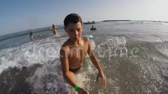 在冲浪板上微笑的男孩视频的预览图