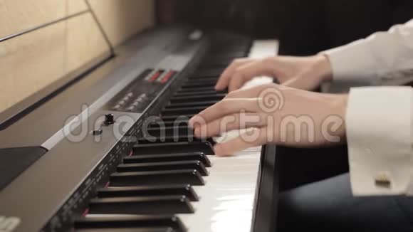 用白色袖子演奏数字钢琴的男性手视频的预览图