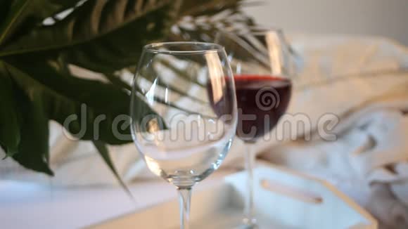 女人的手倒在一杯红酒里浪漫的晚餐概念视频的预览图