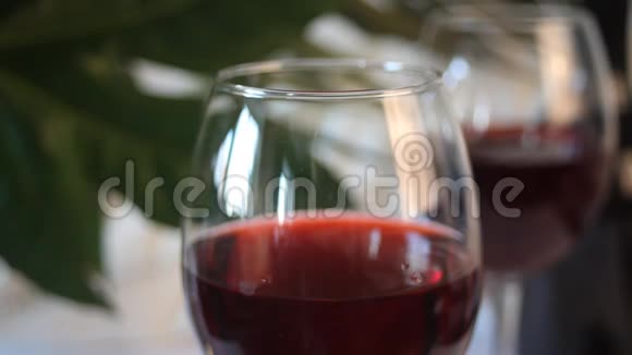 女人手拿一杯红酒背景上的瓶子浪漫的晚餐概念视频的预览图