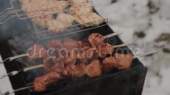 在雪地的背景下在冬天的天气里用火烧烤肉的过程视频的预览图