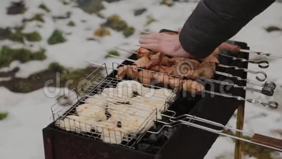 在雪地的背景下在冬天的天气里用火烧烤肉的过程视频的预览图