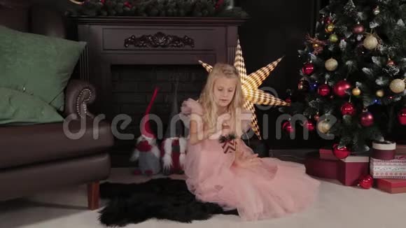 一个十岁的女孩靠近新年树手里拿着一个新年玩具2020年新年视频的预览图