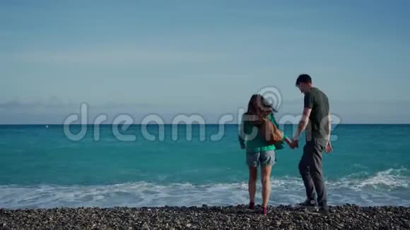 青年男女来到蔚蓝海岸拥抱海浪突然急促起来弄湿了他们的脚情人视频的预览图