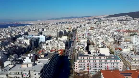 用无人驾驶飞机向前推进的希腊塞萨洛尼基城市环境与建筑物和道路的空中景观视频的预览图