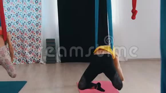 空中瑜伽两个女人在吊床上进行训练靠在后面视频的预览图