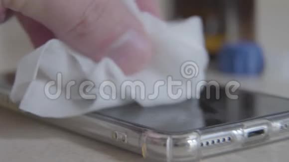 男性白种人用白色消毒餐巾纸擦手机屏幕无法辨认的男人擦拭智能手机的特写视频的预览图