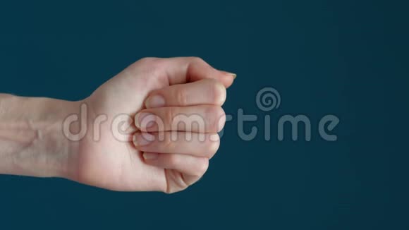 蓝色背景上一只手握着彩色药丸的特写镜头视频的预览图