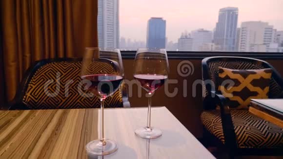 两杯红酒摆在桌上背景为晚城视频的预览图