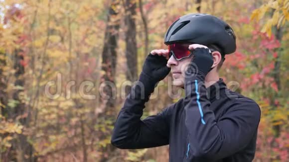 年轻有魅力有动力的男性自行车手脱下自行车设备微笑英俊的职业运动员起飞黑色自行车视频的预览图