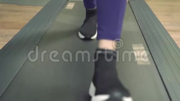 在健身房的跑步机上穿着运动鞋的女性腿部视频的预览图