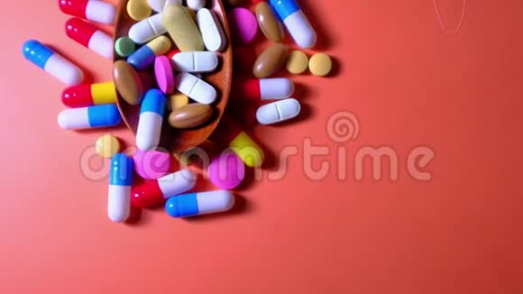 多种五颜六色的药丸和胶囊在勺子上俯视视频的预览图