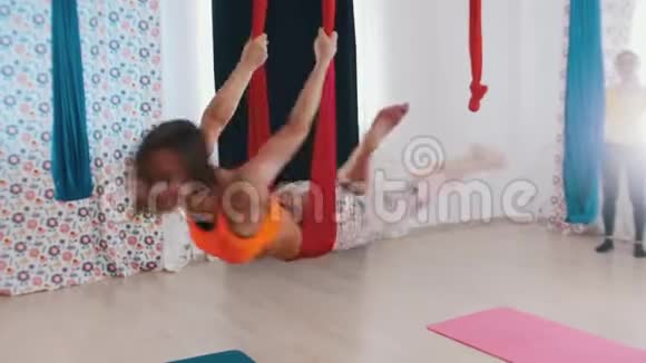 空中瑜伽一个运动的女人吊在吊床上做瑜伽享受乐趣视频的预览图