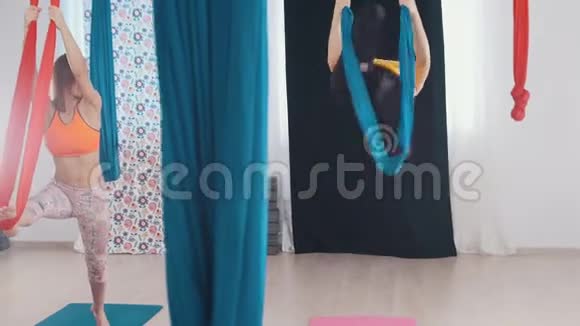 空中瑜伽两个女人进行训练单腿上吊床视频的预览图