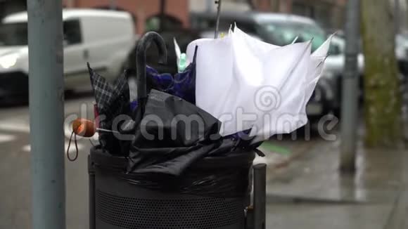 暴风雨期间街上的垃圾桶里有大量的破伞视频的预览图