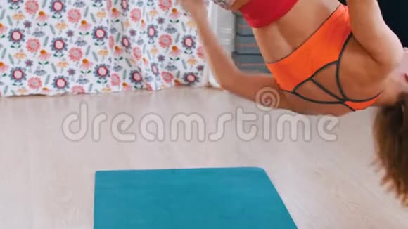空中瑜伽一个运动微笑的女人倒挂在吊床上做瑜伽视频的预览图