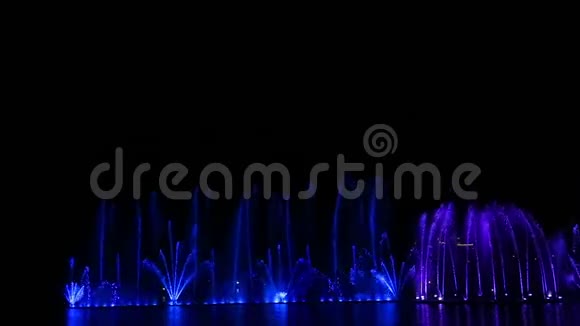 在水中倒影的夜空背景上一个丰富多彩的喷泉表演视频的预览图