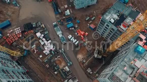 载重卡车通过施工现场焊工和屋顶工在公寓的屋顶上工作无人机视图视频的预览图