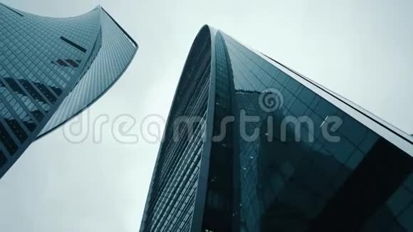 现代玻璃摩天大楼的全景图摄像机从下到上移动旋转然后从上到下移动视频的预览图
