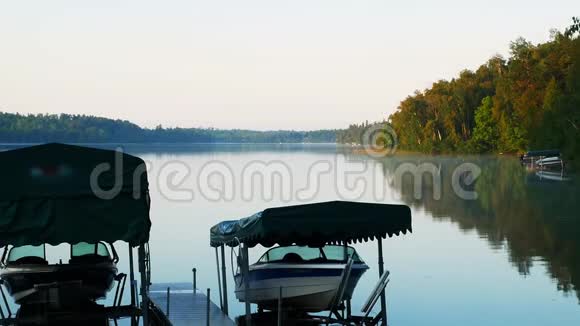 美丽的明尼苏达湖清晨乘升降机乘坐游船平静的水与海岸的倒影视频的预览图