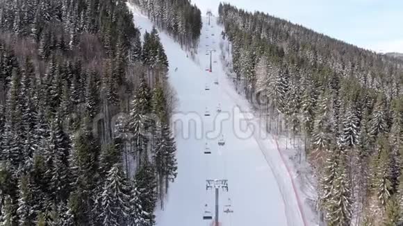 滑雪者在滑雪胜地滑雪升降机附近的高空俯瞰滑雪斜坡Bukvel视频的预览图