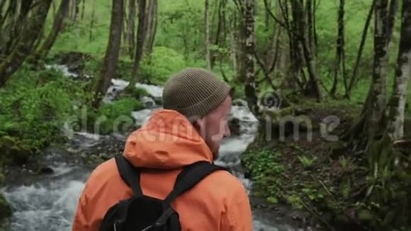 一个人徒步旅行者在森林里和河流一起四处寻找视频的预览图