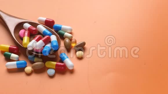 彩色背景汤匙上的多种彩色药丸和胶囊视频的预览图