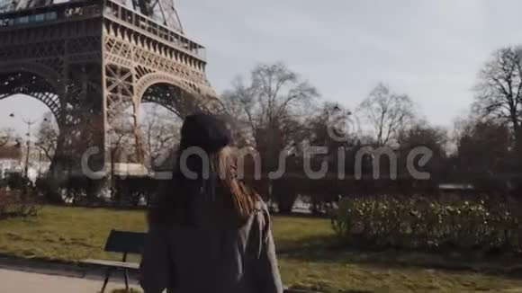 电影中美丽的快乐旅游妇女跑上巴黎埃菲尔铁塔看着相机摆出缓慢的动作视频的预览图