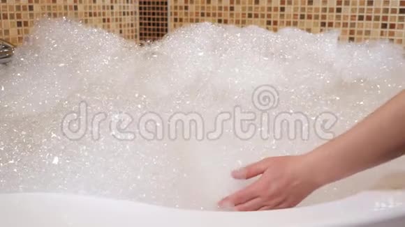 按摩浴缸里有很多泡沫一个女人手碰到泡沫视频的预览图