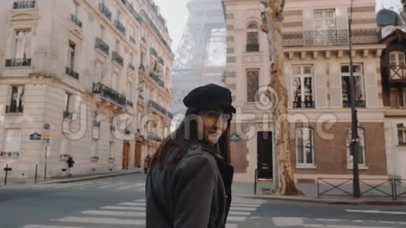 镜头跟随幸福美丽的女人微笑走向埃菲尔铁塔沿着温暖的秋天巴黎街道慢动作视频的预览图
