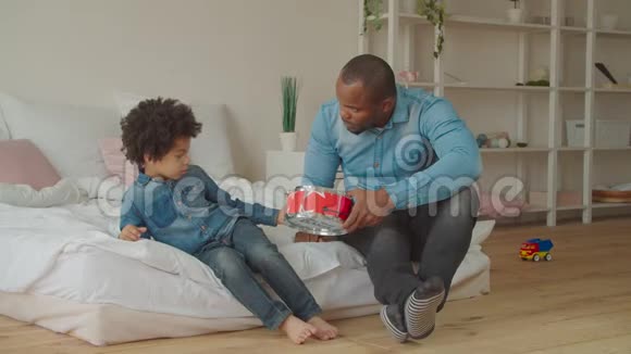 积极的混血男孩在家玩玩具鼓视频的预览图