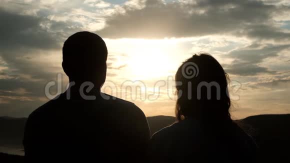 日落时分几个年轻人的剪影一个女人把头轻轻地放在她男人肩膀上视频的预览图