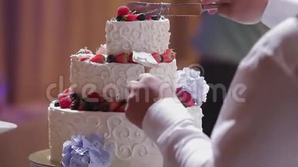 新婚快乐的新婚夫妇在庆祝时切了一个结婚蛋糕视频的预览图