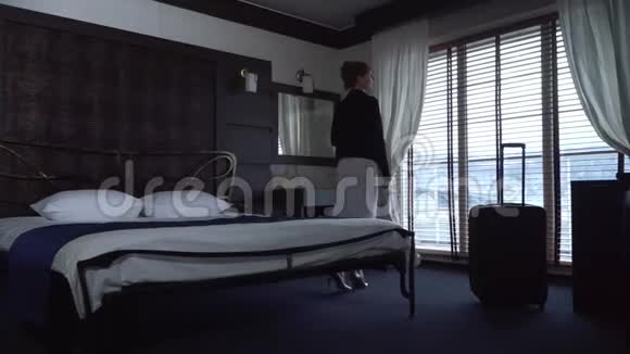 年轻的女人累了躺在酒店房间的床上手提箱就在附近视频的预览图