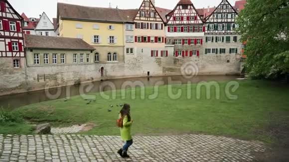 幸福的年轻女子在堡垒墙附近的公园里奔跑和旋转半木制建筑SchwabischHall德国视频的预览图