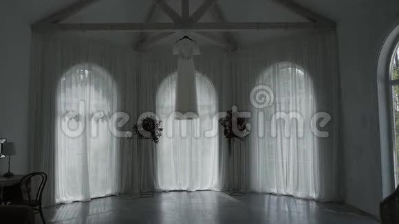 漂亮的现代婚纱挂在房子里视频的预览图