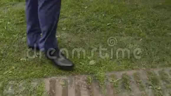 穿裤子的人在草地上行走的腿视频的预览图