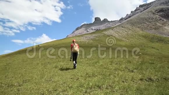 一位女摄影师在岩石和天空的背景下爬上山坡概念摄影旅行视频的预览图