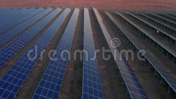 在早春日落时空中无人机在太阳能农场观看大型太阳能电池板太阳能电池发电厂录像视频的预览图