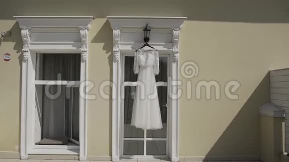 漂亮的现代婚纱挂在窗边的房子里视频的预览图