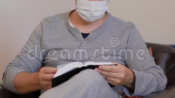 带面具的冠状病毒检疫的意大利青年读一本书视频的预览图
