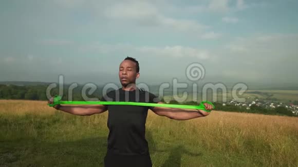 活跃的非洲男人用拉伸橡胶锻炼身体视频的预览图