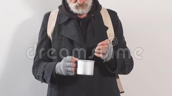 白色背景的工作室里一个无家可归的乞丐的画像从杯子里掏出钞票视频的预览图